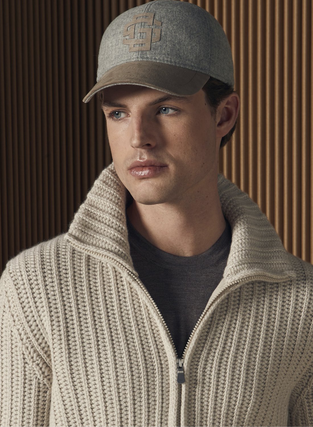Model in grof gebreid vest met rits en pet