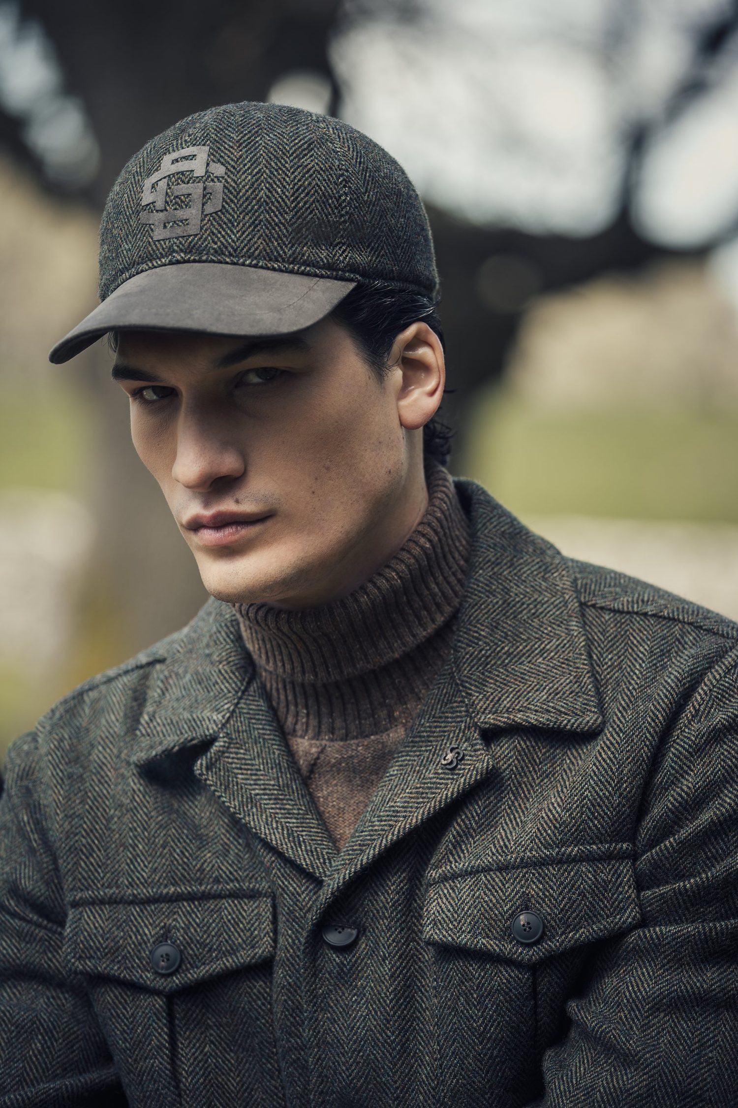 Model in tweed overshirt met pet uit de herencollectie van NERO